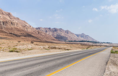 Road by mountain against sky