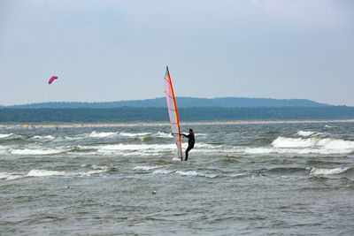 Man surfing on sea against sky