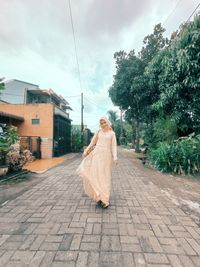 Rear view of woman on street against sky