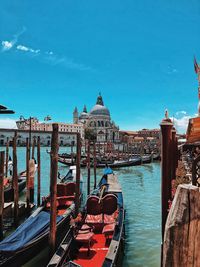 View of wooden post in canal amidst buildings against sky