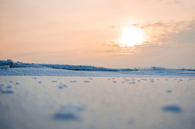 Scenic view of iced river against sky during sunset