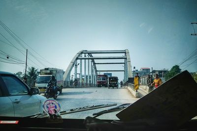 Cars on road against sky in city