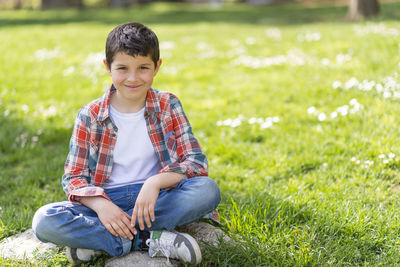Portrait of smiling boy sitting at park