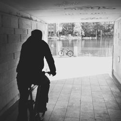 Rear view of silhouette man standing against wall