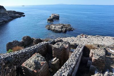 High angle view of rocks by sea against sky