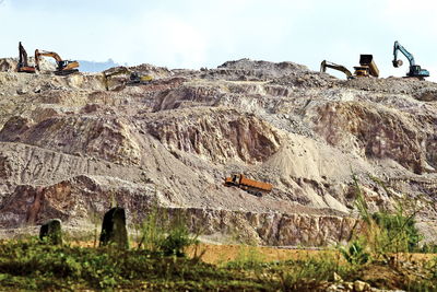 Excavators and trucks doing the work area of the hill.