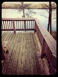 Wooden pier on railing by river