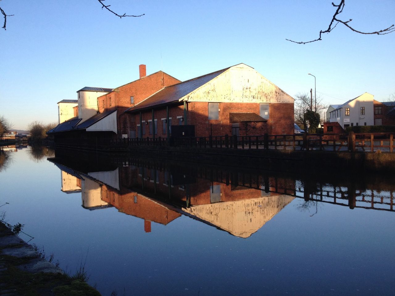 building exterior, built structure, architecture, water, house, clear sky, reflection, residential structure, waterfront, lake, residential building, river, town, roof, standing water, day, outdoors, tree, no people, blue