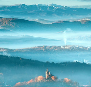 Scenic view of sea by mountains against sky