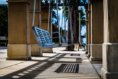 Empty chairs by swimming pool against building