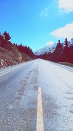 Road by mountains against sky