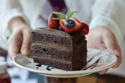 Cropped hand of woman holding cake