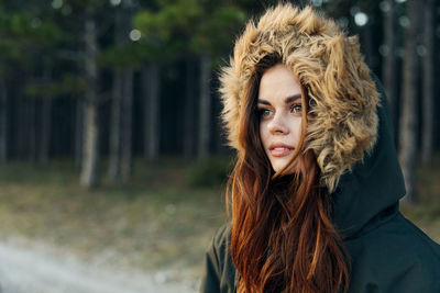 Young woman wearing fur hat while standing outdoors