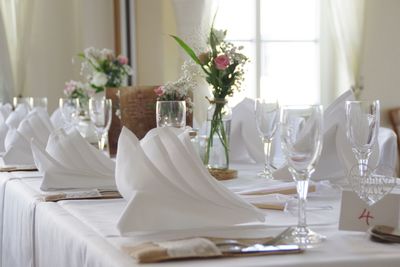 Flower vase and wineglasses on table in dining room