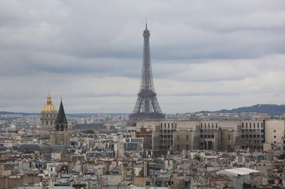 Buildings in city against cloudy sky