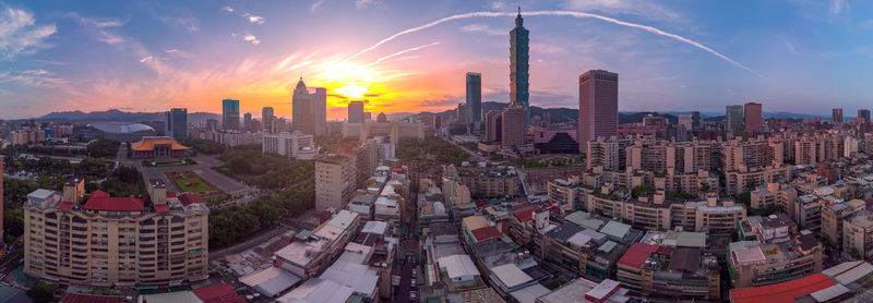 Aerial view of buildings in city against sky during sunset