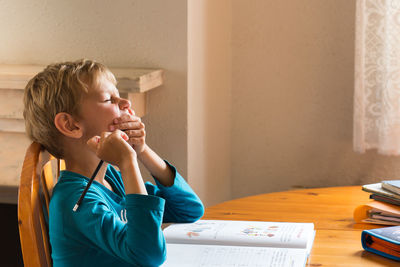 Boy sitting on table at home