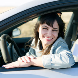 Portrait of smiling young woman sitting in car