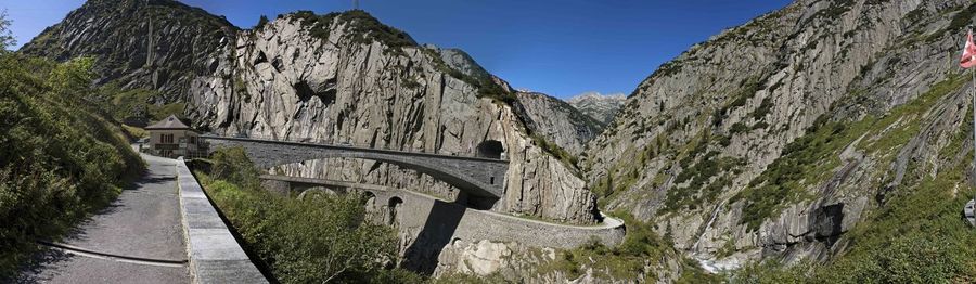 Panoramic shot of bridge over mountains against clear sky