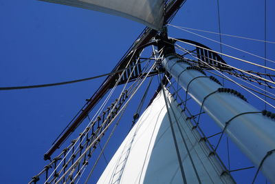 Low angle view of sailboat against clear blue sky