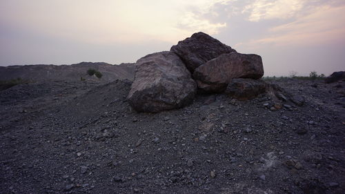 Rock formations on landscape against sky during sunset