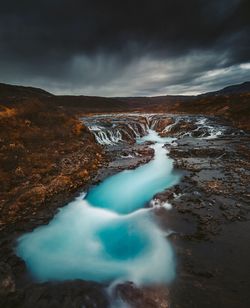 Scenic view of waterfall against sky