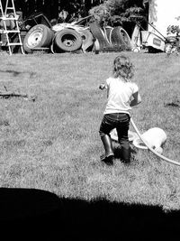 Rear view of girl playing on field