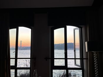 Sea seen through window at sunset