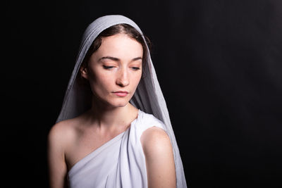 Beautiful young woman in a headscarf on a black background is modest. religion