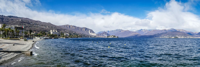 Panoramic shot of sea by mountains against sky