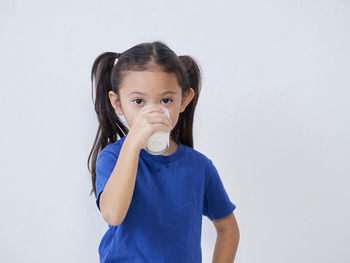 Portrait of a girl standing against white background