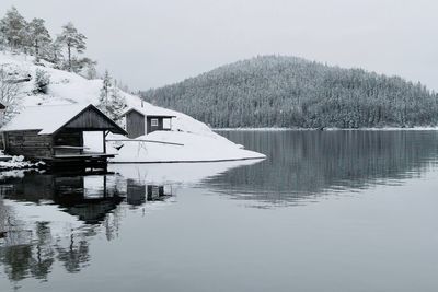 Reflection of house on lake against trees