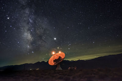 Man sitting against sky at night