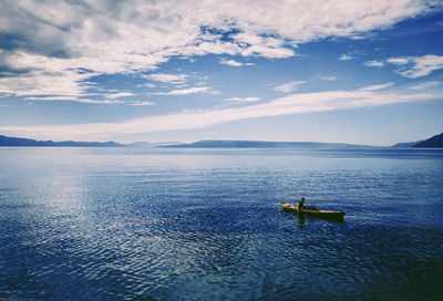 High angle view of man sitting in boat on sea against sky