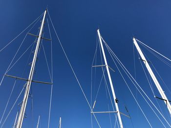 Low angle view of sailboat against clear blue sky