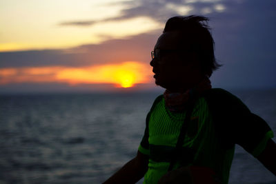 Man wearing sunglasses against sky during sunset