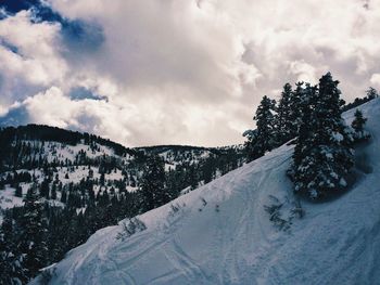 Scenic view of snow covered mountains against cloudy sky