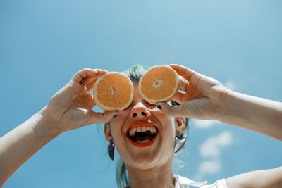 Midsection of man holding ice cream against sky