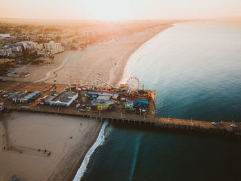 Aerial view of amusement park at beach during sunset