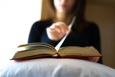 Woman turning the page of a book.