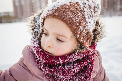 Close-up of girl with snow on hat