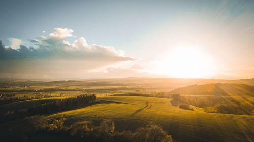 Scenic view of agricultural field against sky during sunset