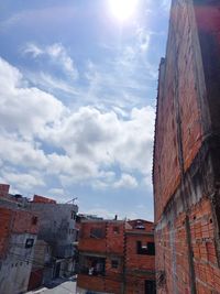 Low angle view of buildings against cloudy sky