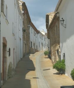 Road amidst buildings against sky