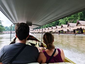 Rear view of people on boat in river