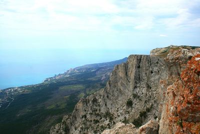 Scenic view of sea and mountains against sky