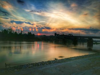 Scenic view of river against sky at sunset