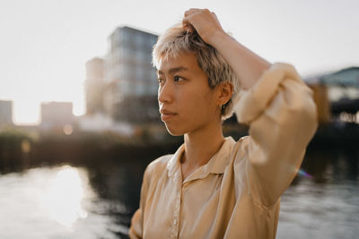 Young woman looking away by the water