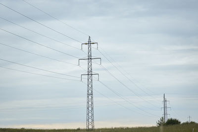 Low angle view of electricity pylon against sky