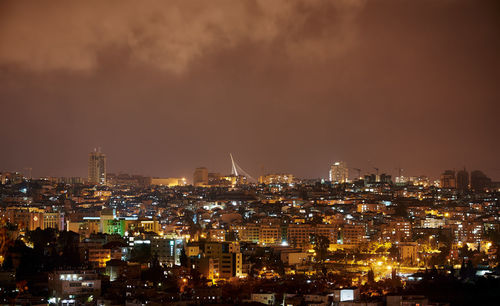 Illuminated cityscape against sky at night